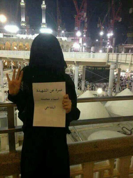 صورة: فتاة سعودية تحمل لافتة بتأديتها عمرة عن أسماء البلتاجي 