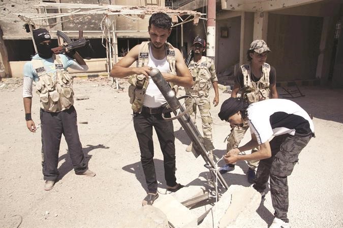 مقاتلو الجيش الحر يحضرون صاروخا محلي الصنع لقصف قوات النظام في دير الزور رويترز