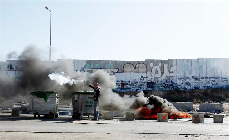 شاب فلسطينيخلال مواجهات مع قوات الاحتلالعقب تشييع جنازة شهداء معسكر قلنديا امس 	رويترز ﻿