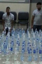 الاسيويان وامامهما المضبوطات من الخمور المحلية
