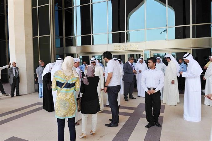 الزميل فرج ناصر وموظفو الاشغال يتابعون الموقف من خارج المبنى﻿
