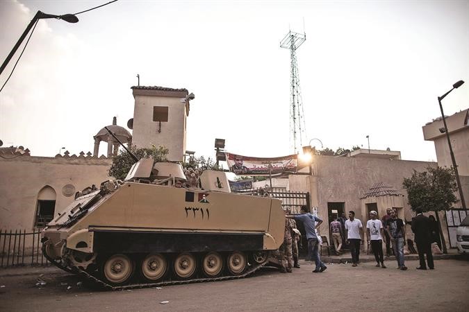 الية عسكرية ومواطنون يقفون بالقرب من قسم بولاق الدكرور اثر انفجار عبوة ناسفة امس الاولافپ