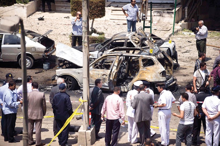 افراد من الامن المصري يعاينون اثار الدمار التي خلفتها محاولة اغتيال وزير الداخلية امس ا ف پ