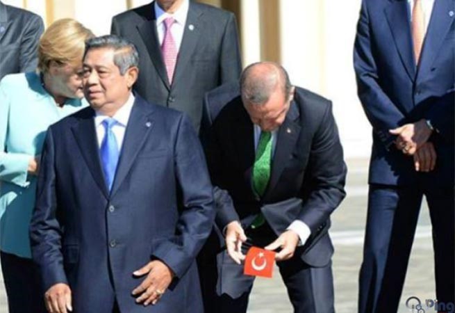 بالفيديو.. أردوغان ينحني ليرفع «علم تركيا» من على الارض وسط دهشة زعماء العالم