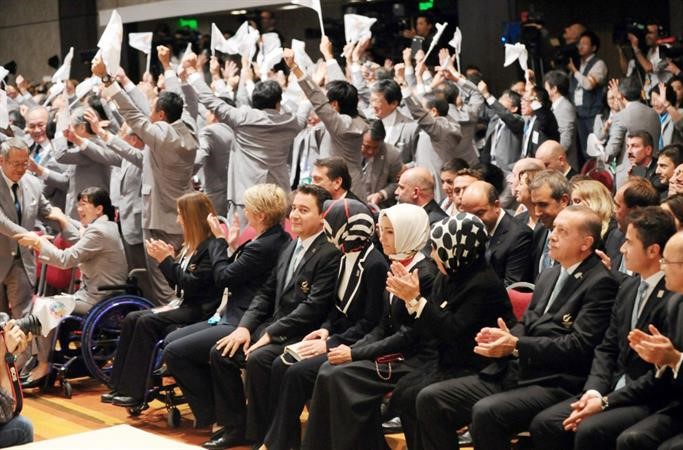 رئيس الوزراء التركي رجب طيب اردوغان وزوجته يصفقان بحسرة لفوز طوكيو والى جانبهما الوفد الياباني فرحا اپ
