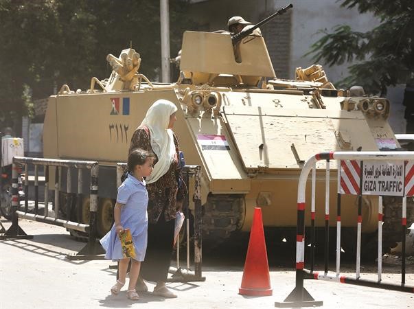مصرية وابنتها امام ناقلة جند تابعة للجيش المصري بالقرب من مديرية امن الجيزة امس اپ