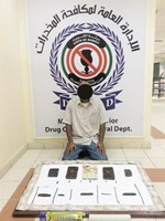 المتهم وامامه كمية الحشيش المضبوطة ﻿