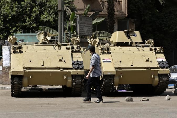 مصري يمشي بجانب مدرعة ناقلة جند في القاهرة امس اپ