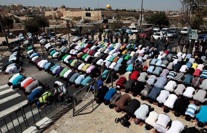 فلسطينيون يؤدون صلاة الجمعة خارج باحات المسجد الاقصى امس بعد ان منعتهم قوات الاحتلال من دخولهرويترز 