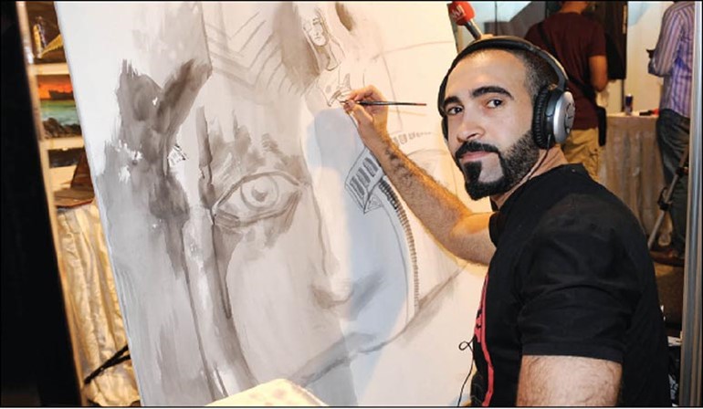 فنان يقوم بالرسم في المعرض