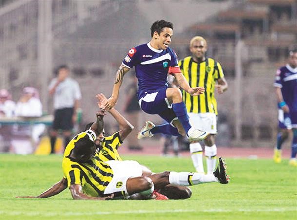 مهاجم الفتح جوزيه التون يقفز فوق لاعب وسط الاتحاد سعود كريري
