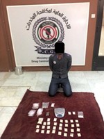 المتهم وامامه كمية المخدرات المضبوطة 