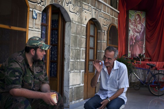 حديث ودود بين ميشال احد مسيحيي حلب وعنصر من الجيش الحر امام دار مار الياس افپ