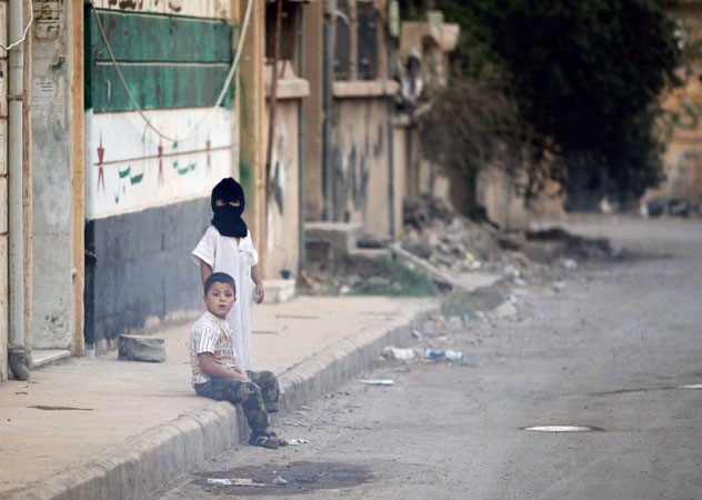 طفل ملثم يلهو مع صديقه في احد شوارع دير الزور رويترز
