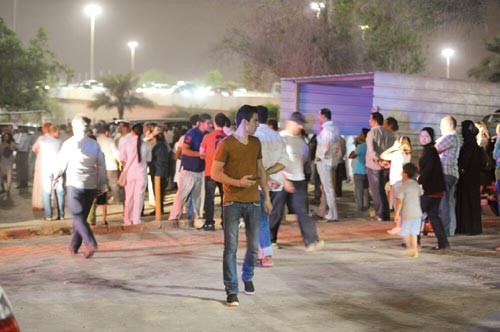 حشد من الناس يتابع عمل الاطفاء في موقع الحريق