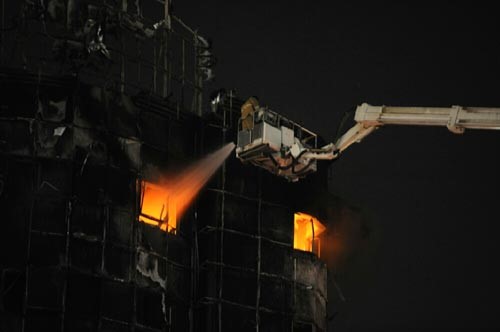 احد رجال الاطفاء يحاول اخماد النيران
