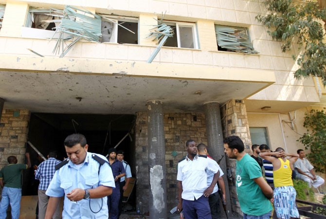 رجال الشرطة الليبية يتفحصون موقع انفجار سيارة مفخخة استهدفت مبنى القنصلية السويدية ببنغازي افب﻿