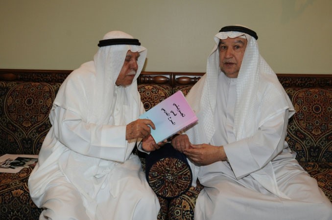 محمد الخضر يطلع الزميل منصور الهاجري على كتابه تجربتي في المسرح المدرسي