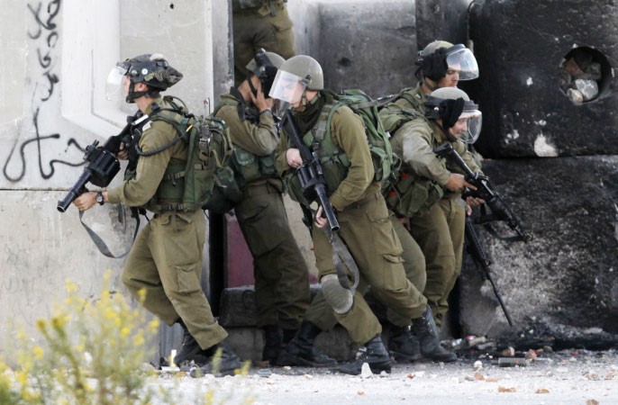 جنود اسرائيليون يحتمون خلف جدار اثناء اشتباكات مع متظاهرين فلسطينيين بالقرب من رام الله امس الاولا ف پ
