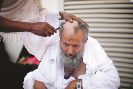 احد الحجاج يتحلل من الاحرام بالحلاقة﻿
