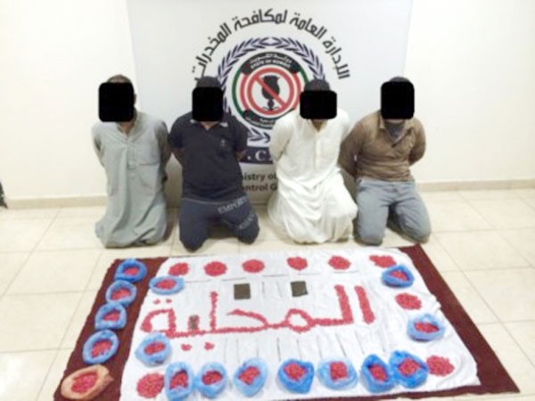 المتهمون الاربعة وامامهم كمية المخدرات المضبوطة