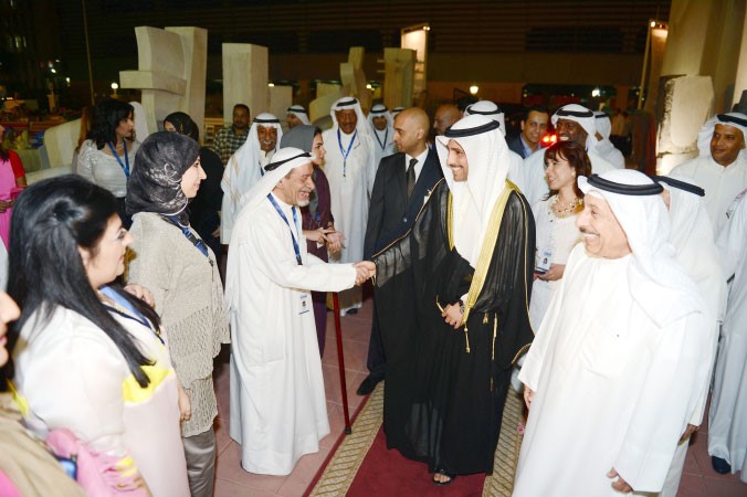 الرئيس الغانم مصافحا احد المشاركين بحضور الفنان التشكيلي عبدالرسول سلمان