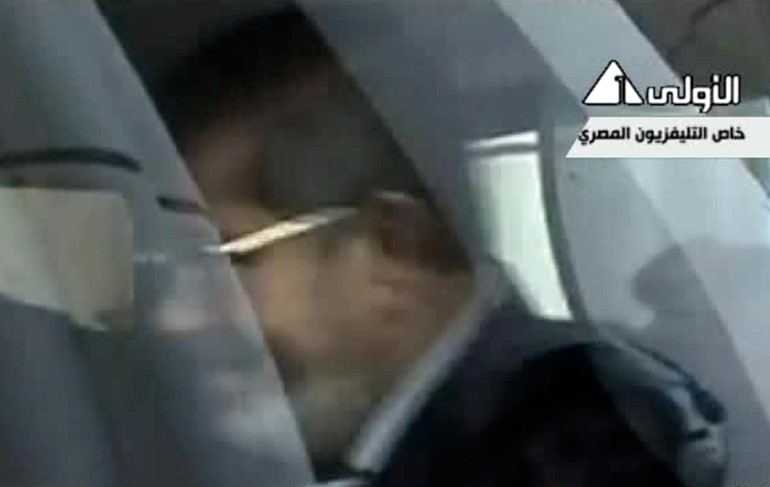 بالفيديو و الصور.. اللقطات الاولى لمحمد مرسي خلف القضبان رافعاً اشارة رابعة 