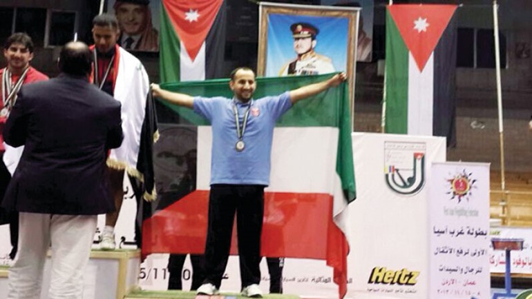 الرباع حسين سعد حاملا علم الكويت على منصة التتويج ﻿