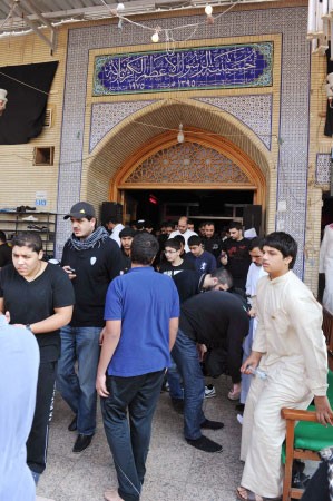 عدد من المعزين خلال خروجهم من الحسينية الكربلائية﻿