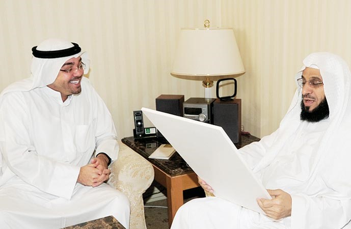 الشيخ عائض يطالع لوحة بعدسة الانباء مقدمة هدية لوالدة الشيخ في ابها من الزميل يوسف خالد المرزوق