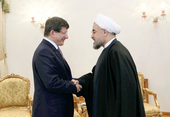 الرئيس الايراني حسن روحاني مستقبلا وزير الخارجية التركي احمد داود اوغلو في طه ران امس ا پ 