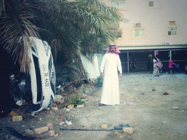 عبدالرحمن العجمي وبجانبه اخر سيارة اقتحمت منزله﻿