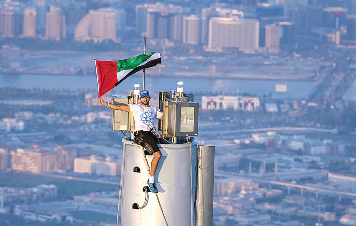 سمو الشيخ حمدان بن محمد بن راشد ال مكتوم يظهر وقد عرض العلم الاماراتي على قمة برج خليفة، اطول برج في العالم في 25 نوفمبر 2013 بمناسبة يوم الاستقلال الامارات 42 وكجزء من الحملة التي اطلقت دبي للفوز في معرض اكسبو العالمى عام 2020 AFP_