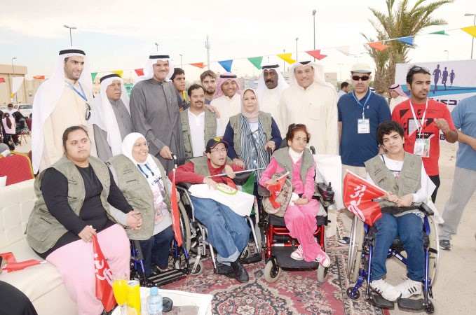 الشيخ سلمان الحمود وخالد الهاجري يتوسطان عددا من ذوي الاحتياجات الخاصة المشاركين في الماراثون وحفل افتتاح الممشى﻿