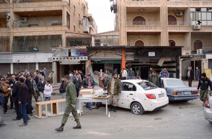 قوات موالية للرئيس بشار الاسد ومدنيون في موقع سقوط قذيفة هاون في حي الفرقان في حلب امس الاول رويترز 