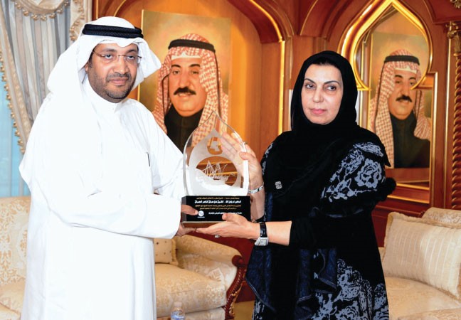 المستشار صلاح الحافظ يقدم درعا تذكارية للشيخة مريم حرم الشيخ علي صباح الناصر رحمه الله