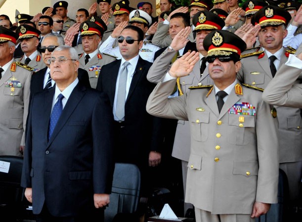 صورة ارشيفية للرئيس المصري المؤقت عدلي منصور وبجانبه وزير الدفاع الفريق عبدالفتاح السيسي خلال مراسم توزيع الميداليات في قاعدة للجيشاپ﻿