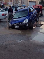 رجال الاطفاء يحيطون بالسيارة العالقة قبل اخراجها
