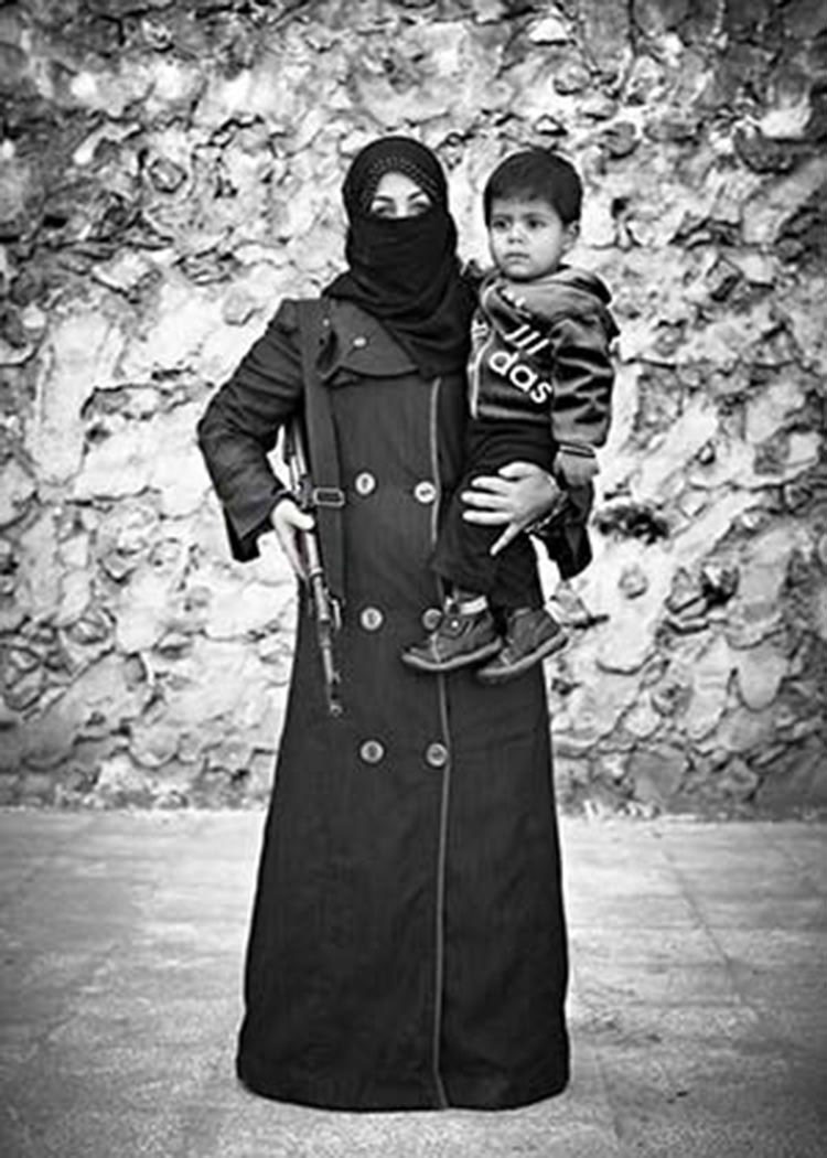 «الجارديان»: أفضل صورة عام 2013.. «سورية» تحمل طفلها وسلاح الكلاشنكوف