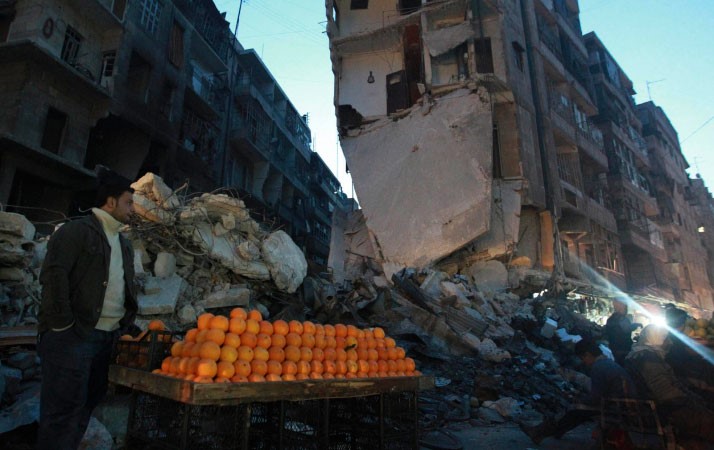 سوري يبيع البرتقال بين الابنية المدمرة في حي الشعار في حلب 	 رويترز﻿