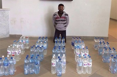 المتهم السيلاني وامامه كمية الخمور المضبوطة﻿