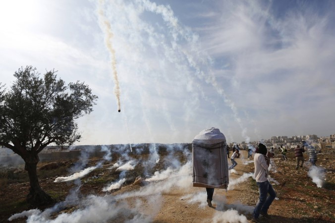 فلسطينيون يرشقون الحجارة على قوات الاحتلال التي قذفتهم بقنابل مسيلة للدموع خلال اشتباكات برام الله امس	 رويترز ﻿