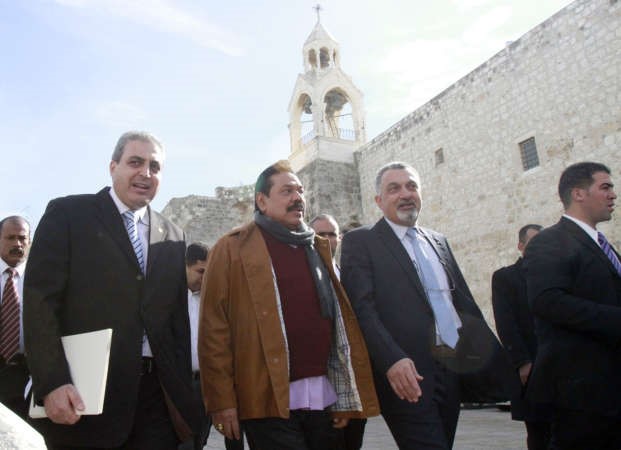 الرئيس السريلانكيالثانيمن اليمين بصحبة مستشار الرئيس الفلسطيني خلال زيارته لاحدى الكنائس ببيت لحم امس	افپ﻿