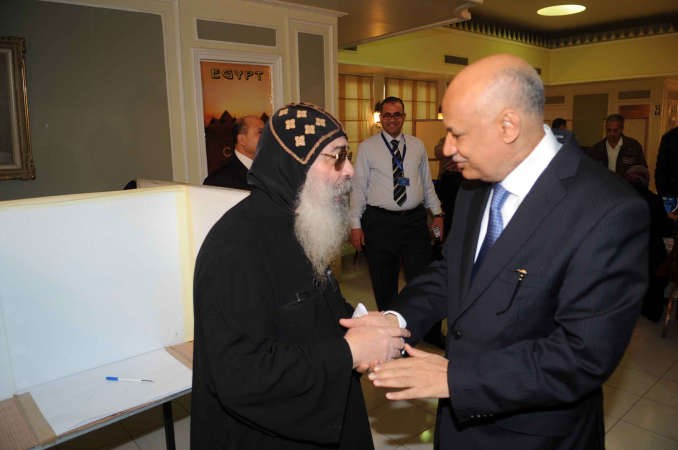 السفير المصري عبدالكريم سليمان مستقبلا الانبا بيجول قبيل ادلائه بصوته في الاستفتاء على الدستور الجديد امس اسامة ابوعطية