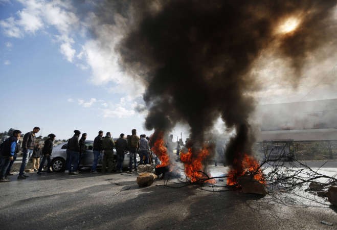 دخان يتصاعدجراء اضرام فلسطينيين النار في اطارات لقطع الطريقبرام الله احتجاجا على معاملة الاسرى امس رويترز 