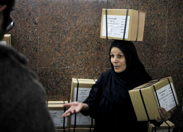 موظفة مصرية تحمل صناديق اوراق الاقتراع في القاهرة امس اپ