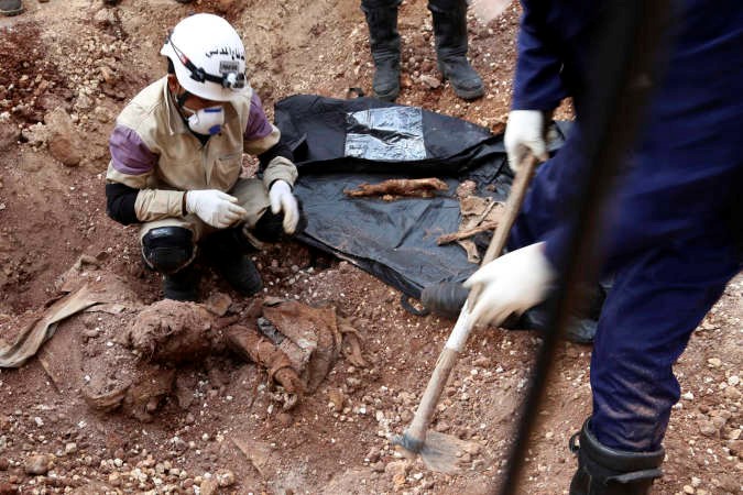 ناشطون وثوار ينتشلون جثثا من جانب مقر قيادة داعش في الشيخ نجار في حلب بعد سيطرة المعارضة عليها رويترز 