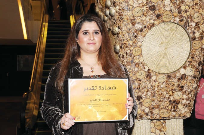الفنانة دلال المطوع تحمل شهادة تقديرها