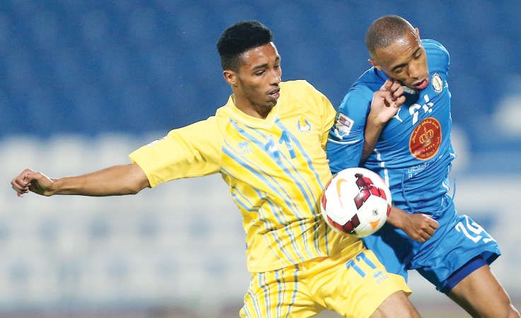 لاعب الخور علي جمعة يصارع لاعب الغرافة مؤيد حسن للحصول على الكرة افپ