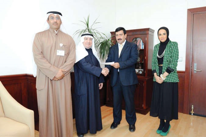 خالد العسعوسي يسلم التبرع لممثل جمعية عبدالله النوري
